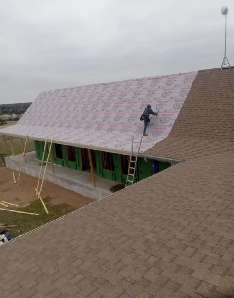 Worker preparing underlayment for a metal roof installation in Mechanicsburg